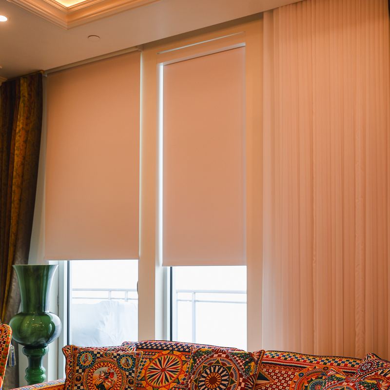 White roller shades on balcony doors, framed by curtain panels on each side